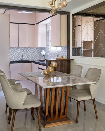 Dining table with marble top and slatted wood base, blush kitchen visible beyond