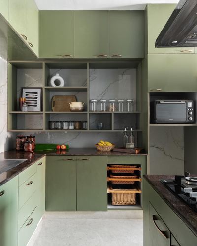 Olive green kitchen with open shelving, marble-look backsplash, and dark countertop