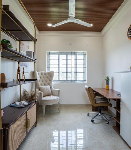 Home study with tufted wingback chair, wooden desk, and slatted wood ceiling with fan