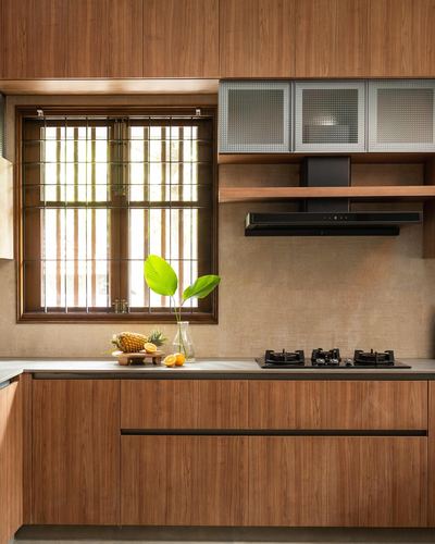Wood-paneled kitchen with slatted window, black hob, and glass-front upper cabinets