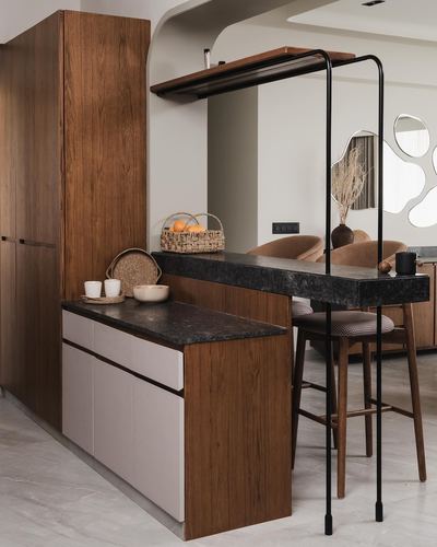 Wooden kitchen with dark stone counter, bar stools, and cane basket of oranges