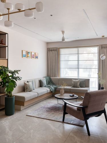 Neutral-toned living room with corner sofa, round coffee table, cane armchair and large window
