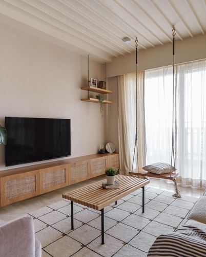 Japandi living room with cane-front TV console, slatted coffee table and hanging swing by window