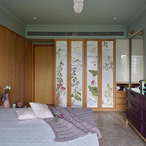 Bedroom with sage walls, fluted wood panelling, and hand-painted botanical wardrobe panels above a bed