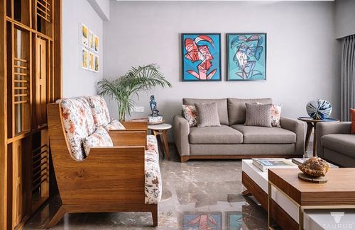 Living room with floral wooden sofas, marble floor, and two teal abstract face paintings on grey wall