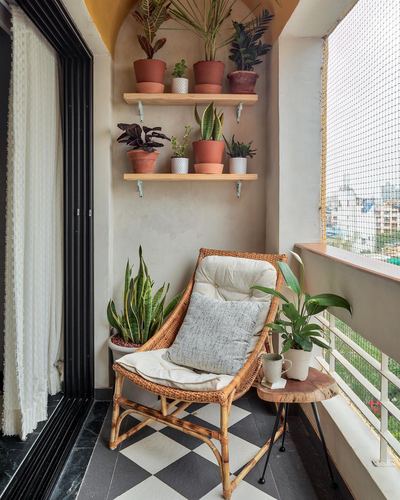 Balcony corner with rattan chair, checkerboard floor, and shelves of potted plants
