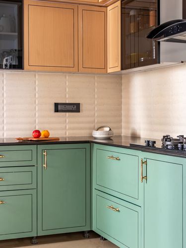 Sage green lower kitchen cabinets with wood upper units and black stone countertop