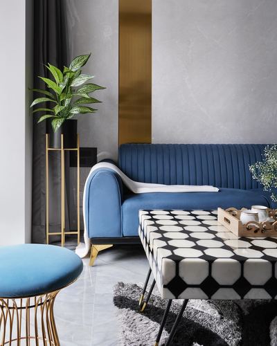Blue channel-tufted sofa beside geometric tiled coffee table and brass-framed stool