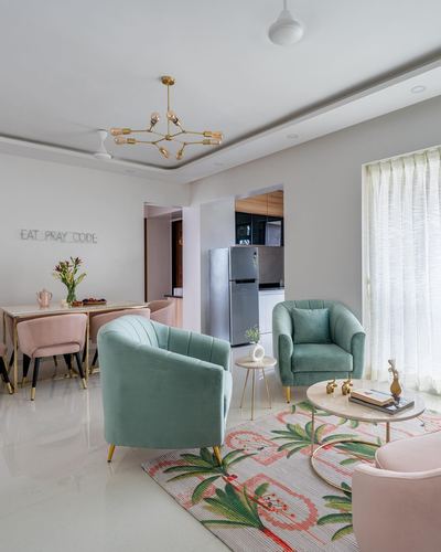 Living room with sage velvet armchairs, blush dining chairs and a brass sputnik chandelier