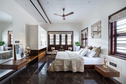 Bedroom with dark marble floor, wooden shuttered windows, and a neutral-toned bed