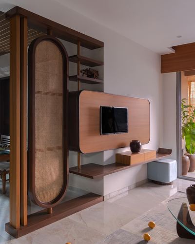 Living room TV console with rounded wood cabinet and oval cane screen divider