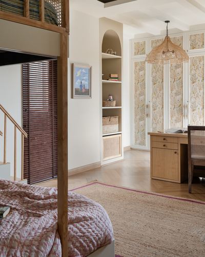 Bedroom corner with four-poster bed, arched shelving niche, and patterned wardrobe with wicker pendant light
