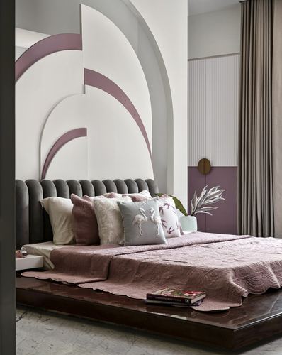 Bedroom with grey channel-tufted headboard, arched pink and grey wall mural, and pink quilted bedspread