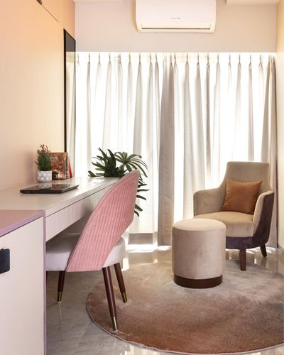 Pink quilted chair and desk beside beige armchair and ottoman near curtained window