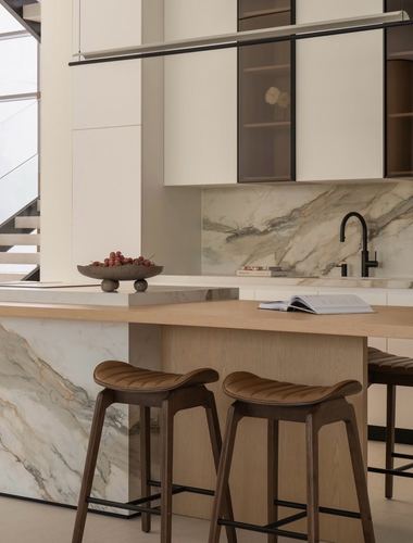 Kitchen island with veined stone waterfall panel, wood countertop, and leather-seated stools