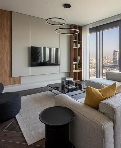 Modern living room with wood panelling, TV wall, city-view window and mustard cushion accent