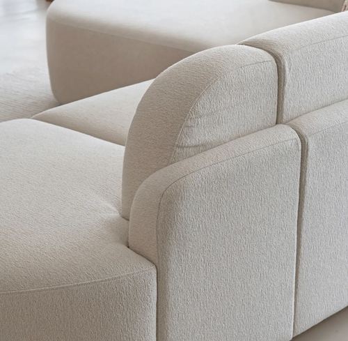 close-up of a cream bouclé sofa with rounded armrest and backrest