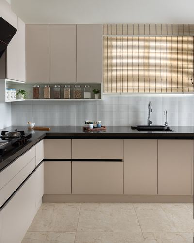 L-shaped beige kitchen with black countertop, ribbed backsplash, and bamboo blind window