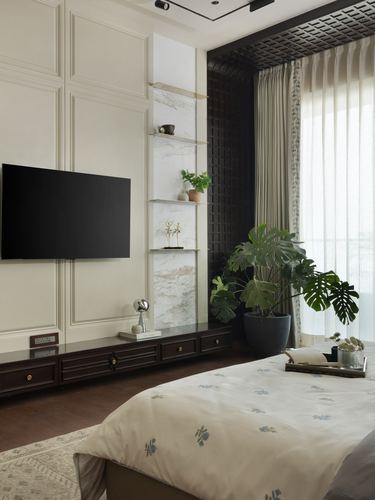 Bedroom with paneled wall, wall-mounted tv, marble niche shelves and dark wood console beside bed