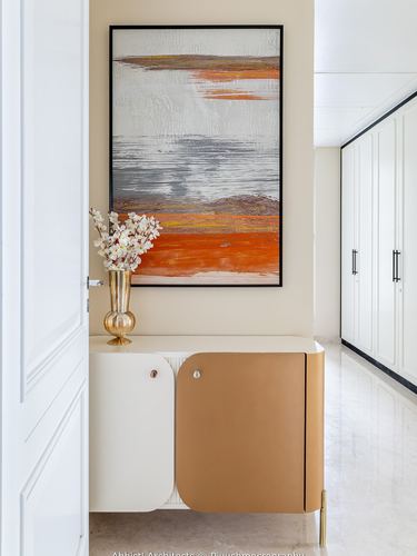 Entryway console with curved tan leather doors below an orange-toned abstract painting