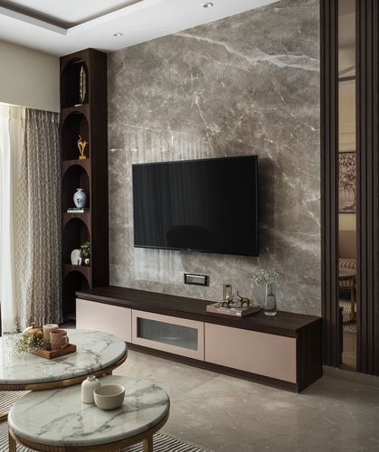 Living room with marble feature wall, mounted tv, pink and wood console, and round marble coffee tables