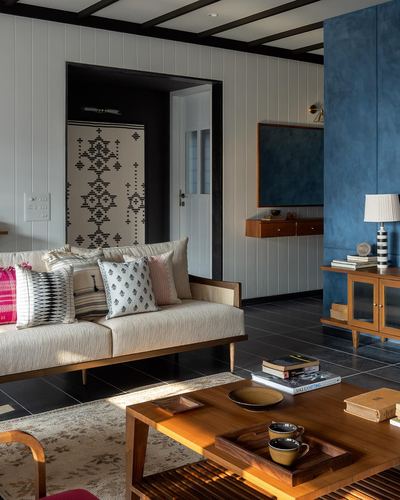 Living room with cane sofa, wooden coffee table, and blue plastered wall column