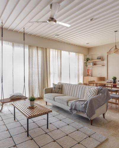 Japandi-style living room with beige sofa, wooden swing, slatted coffee table and geometric rug