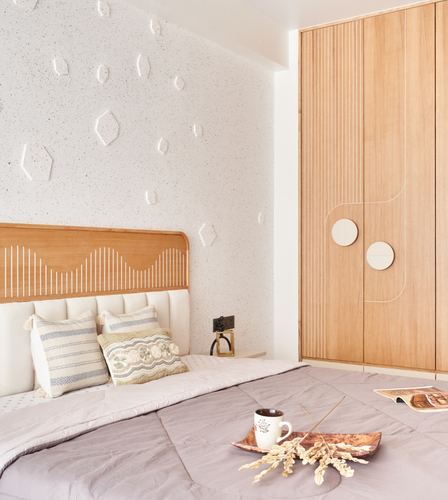 Bedroom with textured stone wall, wood headboard with sunburst pattern, and grooved wardrobe with inlay discs