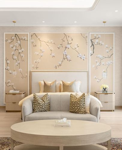 Neutral bedroom with floral panel wall, upholstered bed, curved sofa and round coffee table