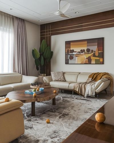 Living room with cream leather sofas, live-edge coffee table, and framed landscape art on wood-panelled wall