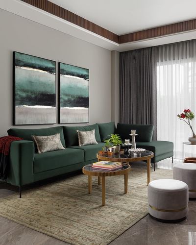 Green velvet sectional sofa with round marble-top coffee tables and abstract diptych art