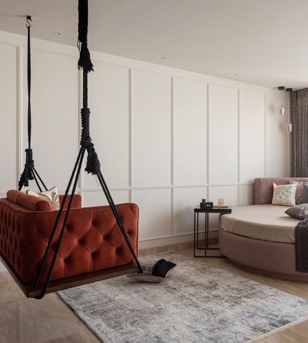 Rust velvet swing sofa hangs beside a round mauve daybed against panelled walls