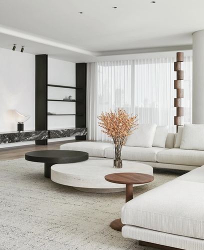 Minimalist living room with layered round coffee tables, white sectional sofa, and sheer-curtained city view