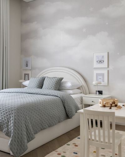 Toddler bedroom with arched upholstered bed, cloud wallpaper, and small white study table