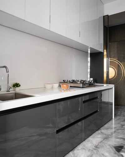 Modern kitchen with glossy charcoal cabinetry, white countertop, gas hob, and marble-look flooring