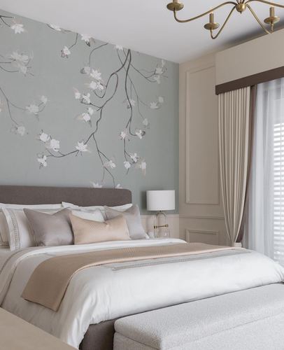 Neutral bedroom with sage floral mural wall, grey upholstered headboard, and layered beige bedding