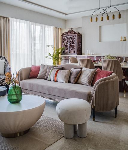 Mauve velvet sofa with layered cushions in living room, carved wood cabinet, marble floor, sheer curtains