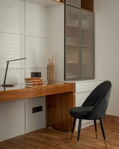 Home study desk in polished wood with black velvet chair and textured cabinet