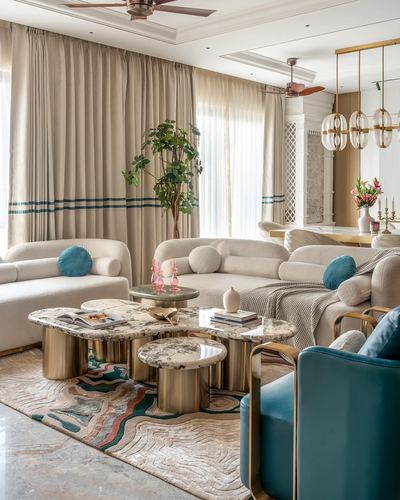 Living room with curved boucle sofas, marble brass coffee tables, and patterned rug