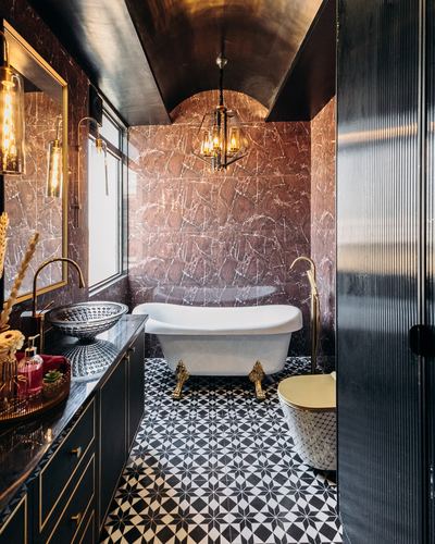Bathroom with maroon marble walls, black-and-white patterned floor, and freestanding clawfoot tub