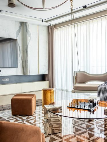 Living room with marble-clad wall, glass table, chess set, and hanging swing chair by sheer curtains