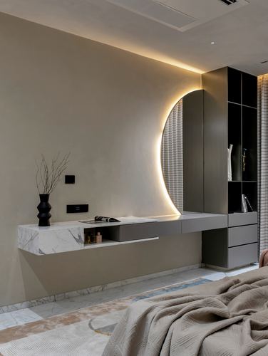 Bedroom vanity with marble console and glowing arched mirror against beige wall