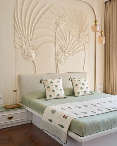 Bedroom with sculpted lotus plaster wall panel above a beige headboard and sage green bedding
