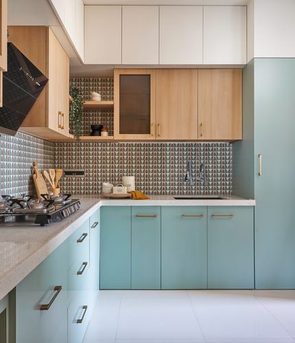 L-shaped kitchen with mint green cabinetry, wood uppers, and patterned tile backsplash
