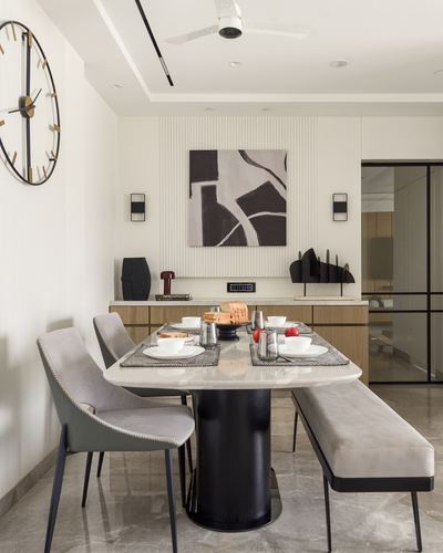 Minimalist dining room with marble table, grey chairs, bench, fluted wall panel and abstract art