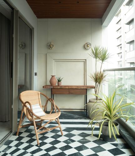 Balcony with rattan chair, live-edge console, plants, on black and white checkerboard marble floor