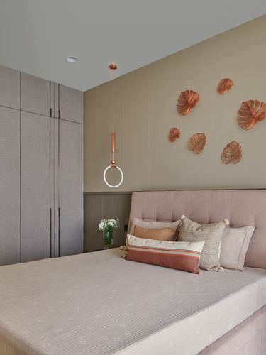 Pink tufted headboard bed with copper leaf wall art and ring pendant light in bedroom