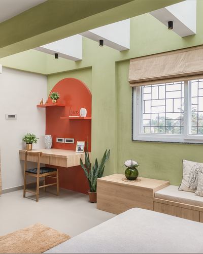 Study nook with arched terracotta wall, floating desk and window seat in green room