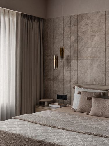 Beige bedroom with fluted stone wall, brass pendant lights, and diamond-textured bedding.