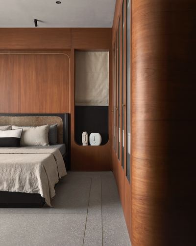Bedroom with wood-panelled walls, cane headboard bed, arched niche and terrazzo floor